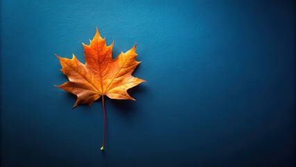 Poster - A Single Autumn Leaf on a Blue Background, Illustrating the Transition from Summer to Fall