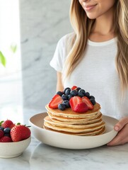 Poster - Delicious stack of golden pancakes topped with fresh strawberries and blueberries on a marble table. Generative AI