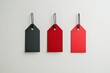 © Graph Squad - Three blank price tags in black and red, hanging against a white background. Perfect for sale promotions or marketing materials.