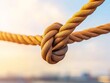 © Manganese - Knotted Rope Against a Blurred Background.