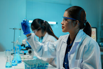Wall Mural - scientists working with test tubes and microscope doing experiments and research in a laboratory