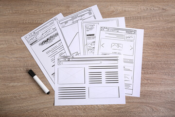 Leinwandbilder - Developing UI design. Sketches of website wireframes and felt pen on wooden table, top view