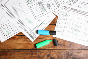 Leinwandbilder - Developing UI design. Sketches of website wireframes and felt pens on wooden table, top view