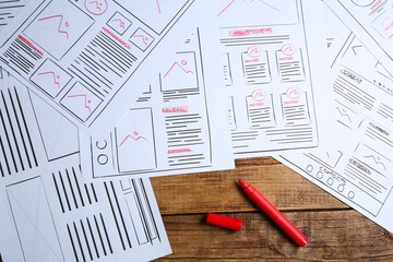 Leinwandbilder - Developing UI design. Sketches of website wireframes and felt pen on wooden table, top view
