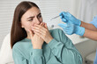 © New Africa - Dental phobia. Dentist working with scared woman in clinic, closeup