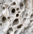 © Pavel Semin - Close-up of a rock wall with holes and circles in a neutral tone for texture and design