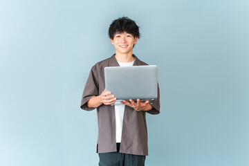 パソコンを持つデジタルネイティブ世代の若い男性