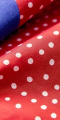 Close-up of fabric featuring a red background with white polka dots.