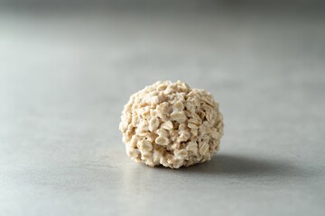 Poster - single scoop of oatmeal resting symmetrically on smooth matte surface under diffused natural lighting