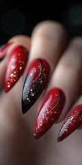 Wall Mural - Close-up of elegant red and black stiletto nails with gold glitter accents.