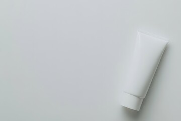 top-down view of minimalist hand cream tube with blank white label lying elegantly on plain white surface with gentle