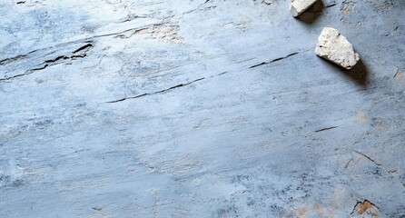 Poster - A textured blue surface with two small stones scattered on it.