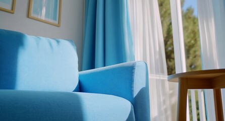 Poster - A cozy blue sofa in a bright room with natural light and curtains.
