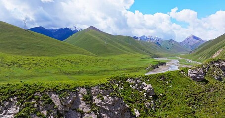 Wall Mural - Curved river and green grassland with mountain natural landscape in Xinjiang. Beautiful scenery along the Duku Highway in China.