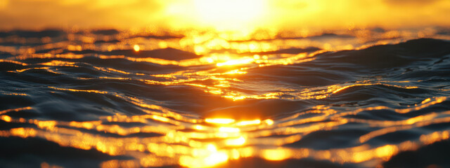 Wall Mural - The sun is setting over the ocean, casting a warm glow on the water