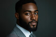 © DesignMaster360 - A portrait of a serious, well-groomed Black man in a gray suit.