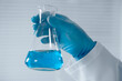 © YURIMA - A dedicated scientist holds an Erlenmeyer flask with vibrant blue liquid, conducting experiments in a wellequipped lab, significantly contributing to advancements in science and technology