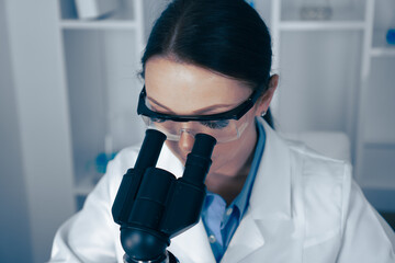 Aufkleber - In a modern lab, a dedicated female scientist analyzes samples under a microscope, demonstrating her expertise and commitment to research and scientific discovery, significantly advancing the field