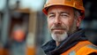 © Alex - Senior construction worker in hard hat smiling at worksite