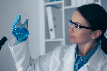Aufkleber - In a wellorganized lab, a dedicated scientist analyzes a vibrant blue solution, highlighting the importance of precision, detail, and rigorous investigation in biochemistry research