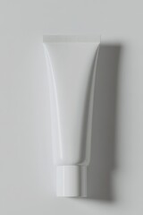 top-down view of minimalist cosmetic tube with blank white label elegantly arranged on pristine white surface