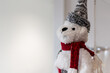 © davidrbcelta - Adorno navideño de oso polar de peluche con bufanda roja y gorro tejido, colocado sobre fondo blanco, ideal para decoración festiva y acogedora.