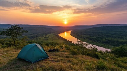 Poster - Camping spot on a hill with a panoramic view of the sunset over a quiet river valley