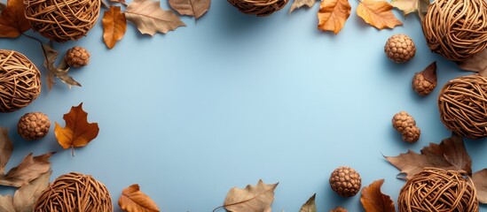 Poster - wicker frame with dry leaves and wicker balls on blue background creating a nature-inspired backdrop