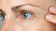 © Kunut - Extreme close up of mature woman face, showcasing fine lines and skin texture around eye area, highlighting natural beauty and aging gracefully