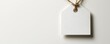 © Vadym - Blank white fabric tag hangs on string against white background. Minimalist design. Stylish branding template. Empty space for text logo. Useful for product branding mockups. Perfect for fashion