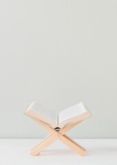 Poster - Tranquil Minimalism Open Quran Resting on Wooden Stand Against Soft Background