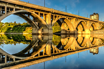 Wall Mural - A bridge with a reflection of the sky and the city in the water