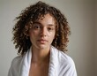 © Iqra - A woman with curly hair wrapped in a towel