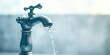 © Vibrant Visions Pixe - Close-up of a silver faucet with water flowing from the spout against a blurred background