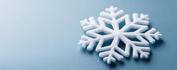 Poster - Snowflake abstract background idea. A close-up view of a delicate white snowflake against a serene blue background.