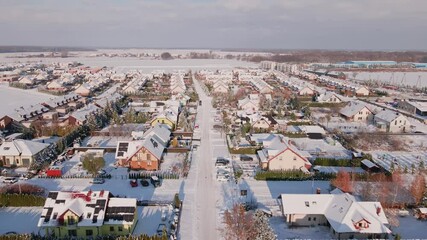 Wall Mural - Aerial view of residential neighborhood with houses and road streets covered in snow. European small town at winter season