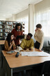 © Westend61 - Group of students having discussion in library