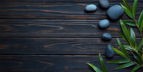 Poster - Dark wood background with smooth grey stones and bamboo leaves.