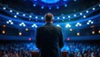 © Diclonius - View of a Businessman Standing on a Stage Under Bright Spotlights, Addressing a Large Audience, Ideal for Leadership, Public Speaking, or Corporate Events