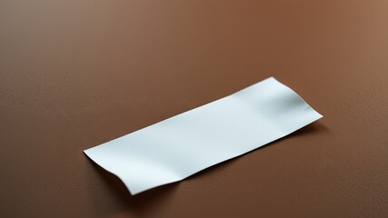 Blank white label on brown surface, perfect for product tagging or design mockups.