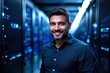 © ThomasLENNE - portrait of a smiling senior Panamanian male IT worker looking at the camera, against dark server room  background.