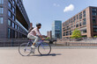 © Westend61 - Man wearing backpack and riding bicycle near buildings in Hamburg, Germany