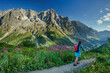 © Westend61 - Woman walking with hiking pole on footpath near Grandes Jorasses mountain