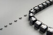 © izzuan - A row of black cubes with white arrows pointing in different directions. A change in course or a shift in strategy concept.