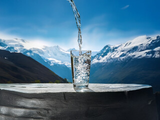 Aufkleber - Crystal-clear water pours into a glass against a breathtaking backdrop of snow-capped mountains under a vibrant blue sky.  The scene evokes purity and refreshment.
