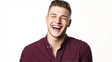 Young Man in Maroon Shirt Laughing Joyfully Against White Background