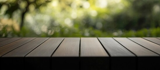 Wall Mural - dark wooden tabletop with a smooth finish against a blurred bokeh background perfect for product sho