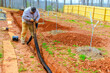 © ungvar - Worker installs drainage pipes in backyard to ensure proper water management for enhance water flow management