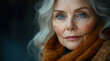 © progressman - A woman with blue eyes and gray hair is wearing a brown scarf