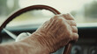 © Bonsales - Aged hand gripping vintage wooden steering wheel, senior driver navigating classic automobile with experienced confidence
